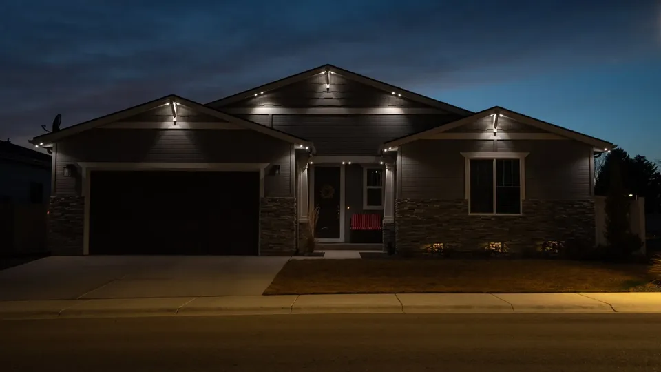 The same house from the same spot with the same runs in cool white, the stone and siding reading gray and blue under it.