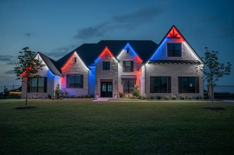One gable in red, the next in blue, across a wide estate front with the eave line left white.