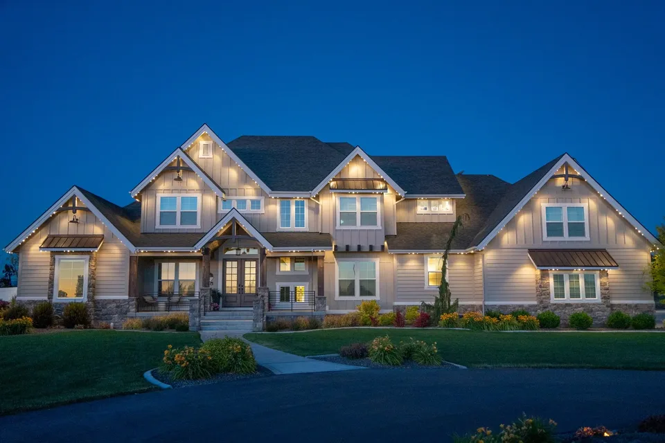 Warm white picking out every gable and eave, on a large craftsman at dusk.