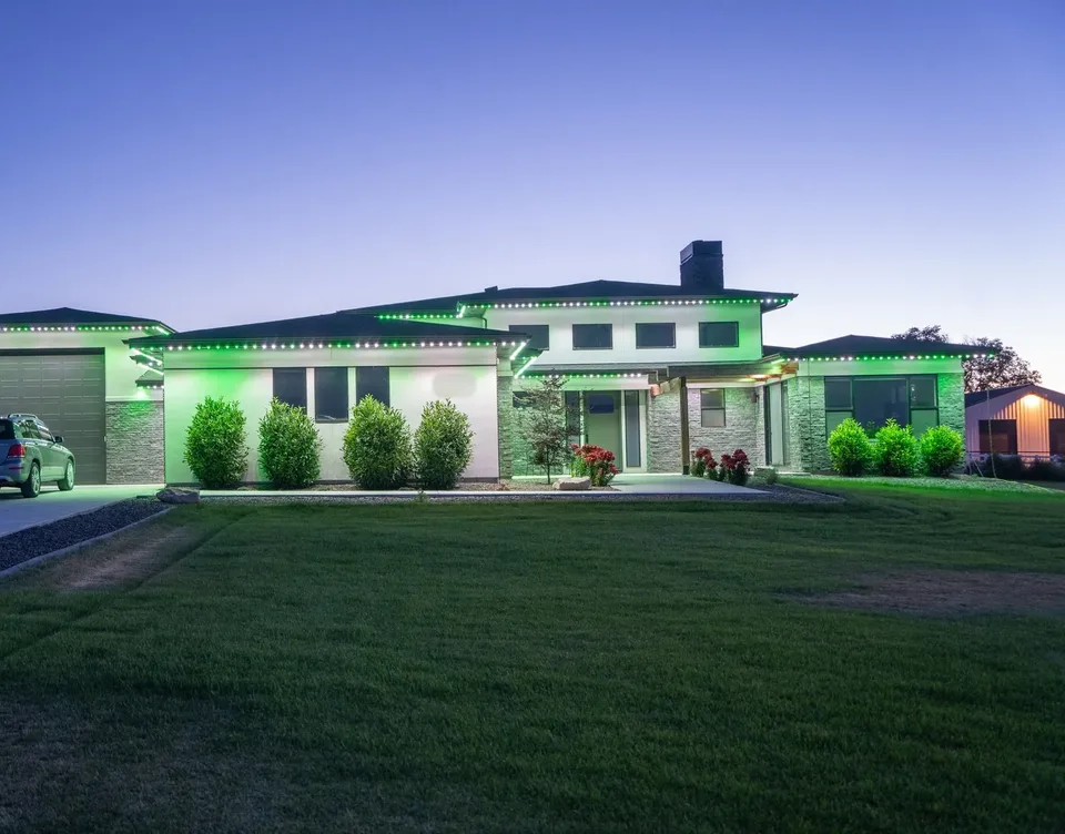 Green and white in short alternating blocks along every roofline of the same long single story house, the stone and stucco washed green.