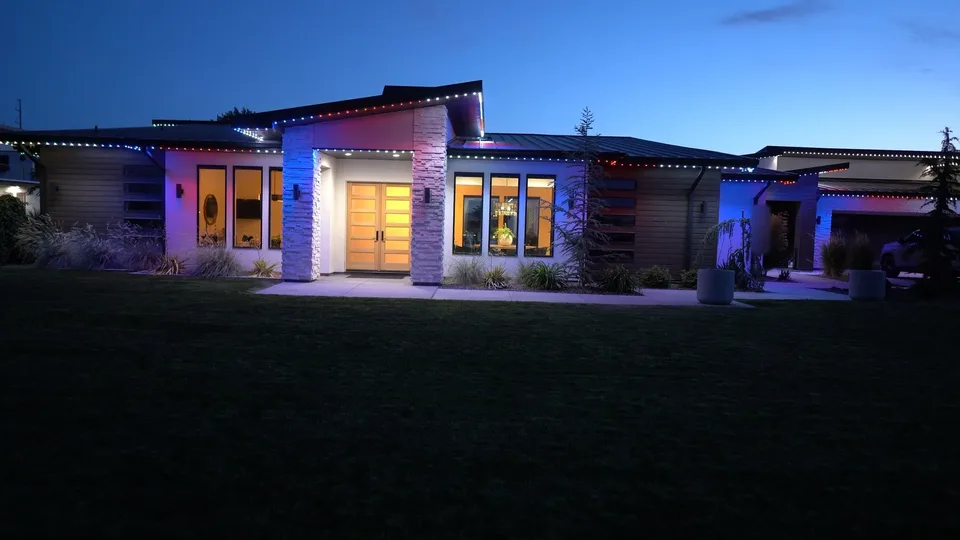 A modern ranch at early dusk, in red, white and blue.