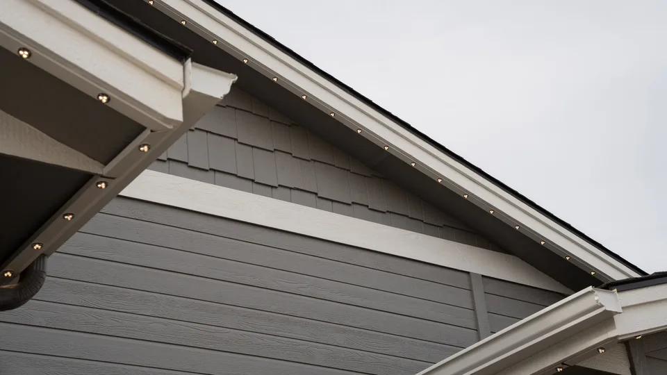A long run of slim channel following a rake board in daylight, reading as a trim line along the roof edge.